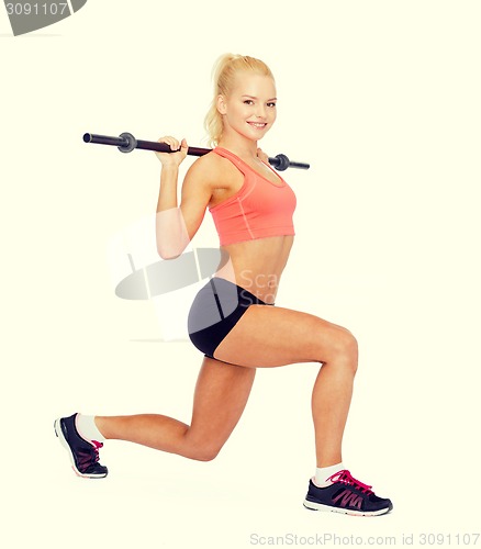 Image of smiling sporty woman exercising with barbell