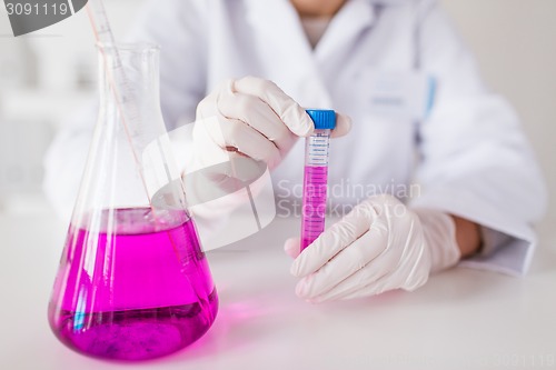 Image of close up of scientist with tube in laboratory