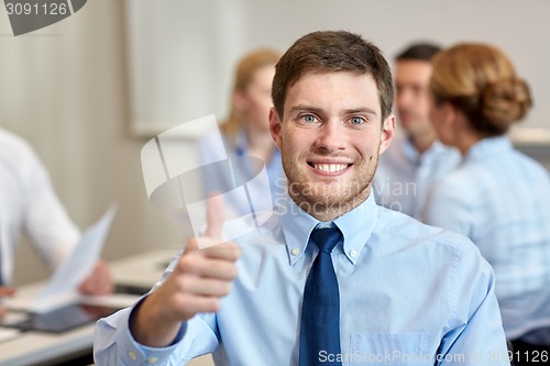 Image of group of smiling businesspeople meeting in office