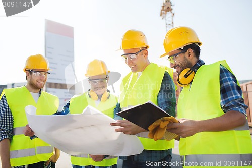 Image of group of builders with tablet pc and blueprint