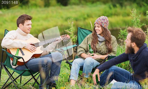 Image of group of tourists playing guitar in camping
