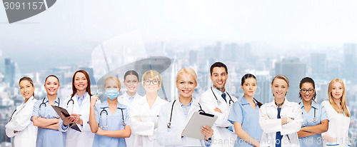 Image of smiling female doctors and nurses with tablet pc