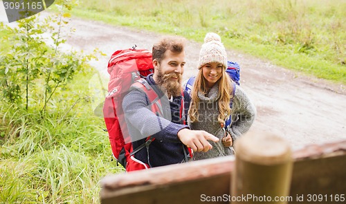 Image of smiling couple with backpacks hiking