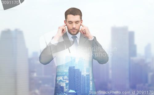 Image of annoyed businessman covering ears with his hands