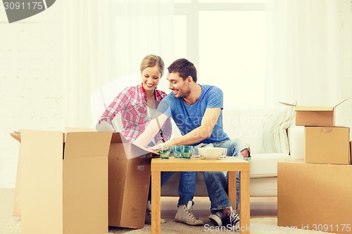 Image of smiling couple unpacking kitchenware