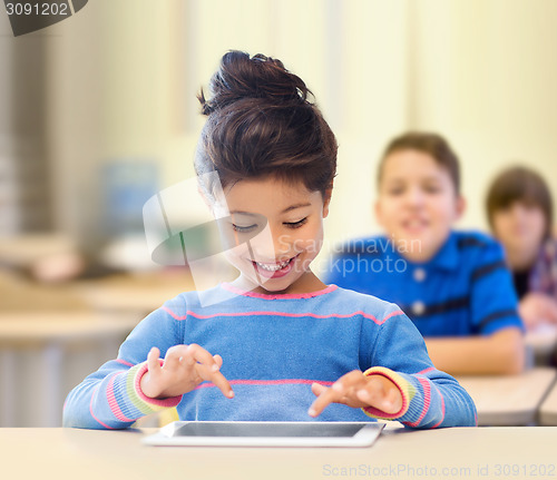 Image of little school girl with tablet pc over classroom