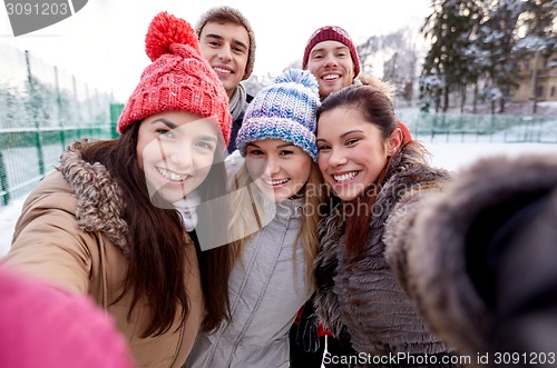 Image of happy friends taking selfie with smartphone