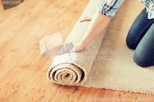 Image of close up of male hands unrolling carpet