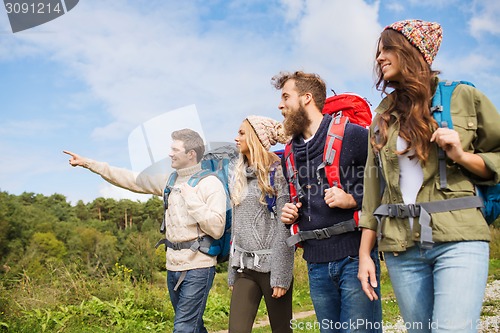 Image of group of smiling friends with backpacks hiking