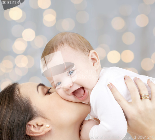 Image of happy mother with baby over lights background