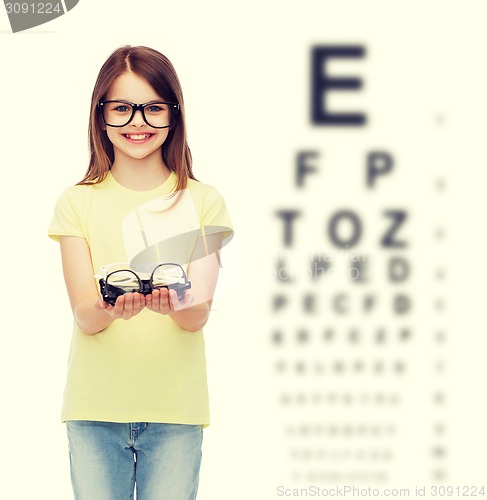 Image of smiling cute little girl in black eyeglasses