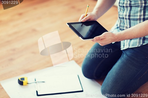 Image of male with tablet pc, blueprint and measuring tape
