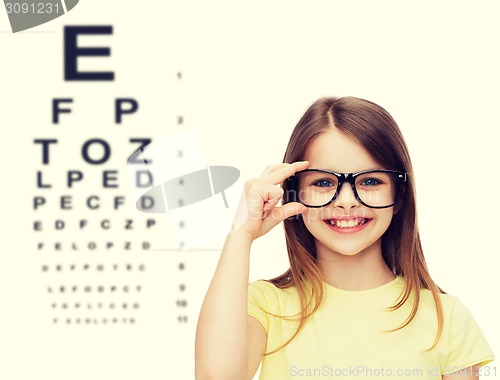 Image of smiling cute little girl in black eyeglasses