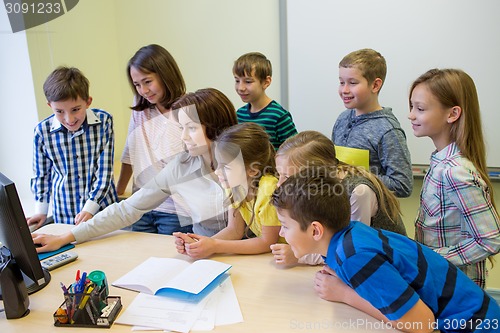 Image of group of kids with teacher and computer at school