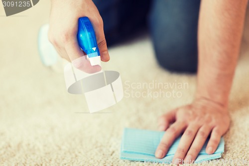 Image of close up of male cleaning stain on carpet