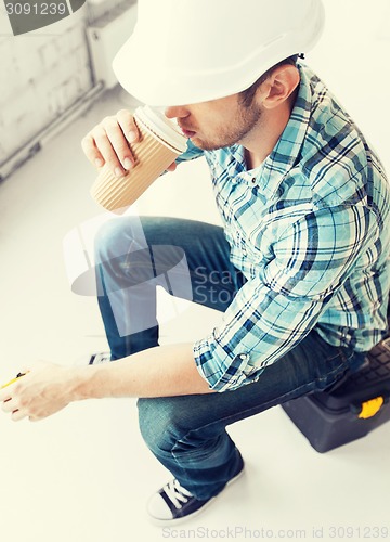 Image of builder drinking take away coffee