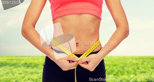 Image of close up of female hands measuring waist