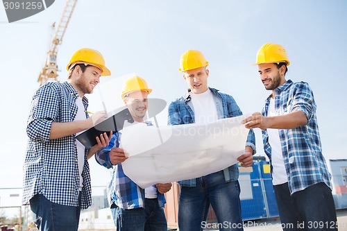 Image of group of builders with tablet pc and blueprint