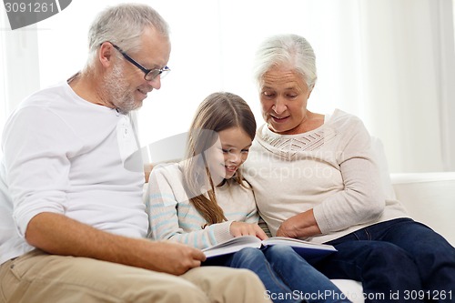 Image of smiling family with book at home