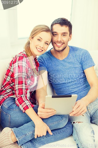 Image of smiling happy couple with tablet pc at home