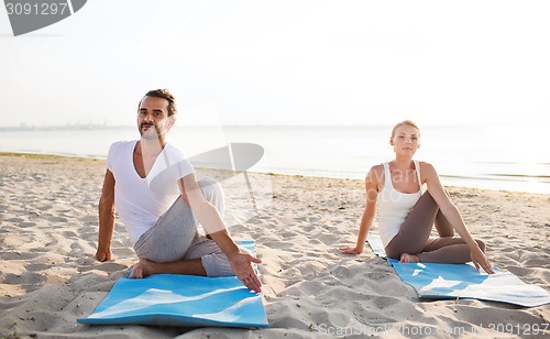 Image of couple making yoga exercises outdoors