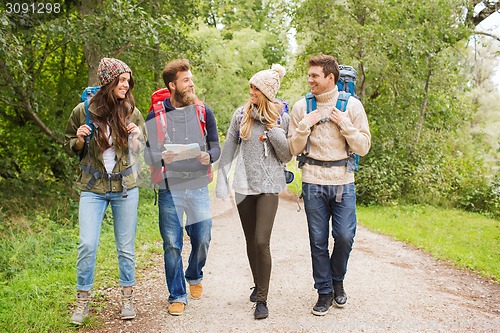 Image of group of smiling friends with backpacks hiking