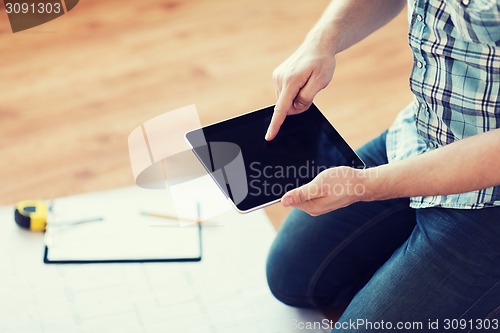 Image of male with tablet pc, blueprint and measuring tape