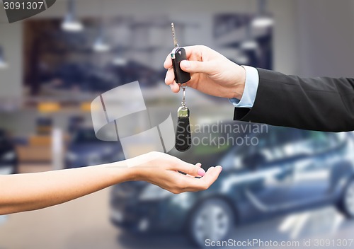 Image of close up of customer and salesman with car key