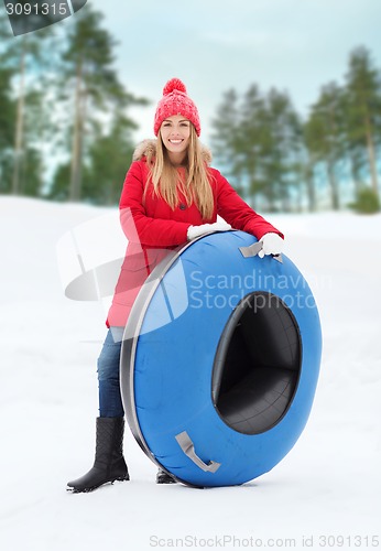 Image of happy teenage girl or woman with snow tube