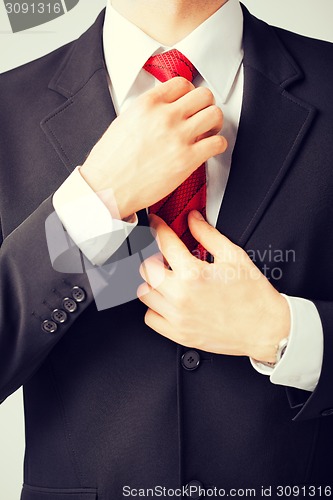 Image of man adjusting his tie