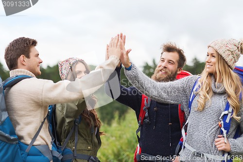 Image of group of smiling friends with backpacks hiking