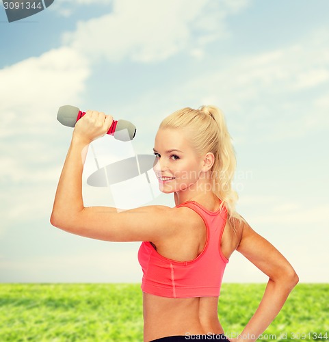 Image of young sporty woman with light dumbbell