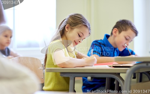 Image of group of school kids writing test in classroom