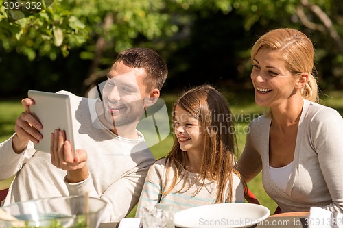 Image of happy family with tablet pc outdoors