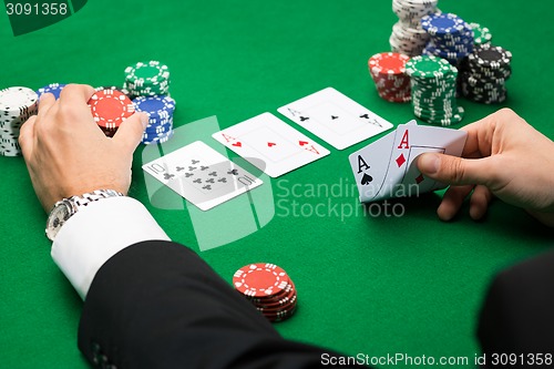 Image of poker player with cards and chips at casino