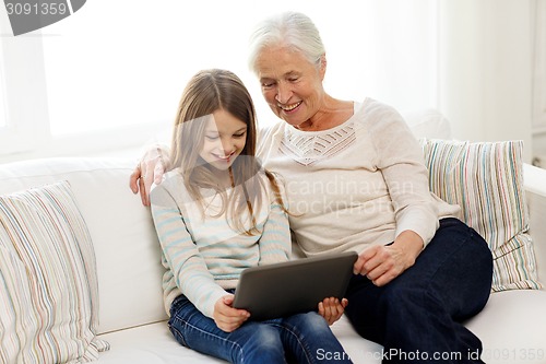 Image of smiling family with tablet pc at home