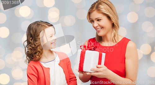 Image of happy mother and daughter with gift box