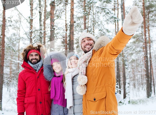 Image of group of smiling men and women in winter forest