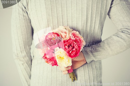 Image of man hiding bouquet of flowers