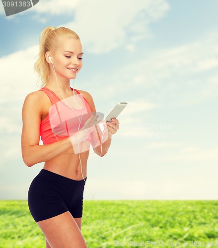 Image of smiling sporty woman with smartphone and earphones