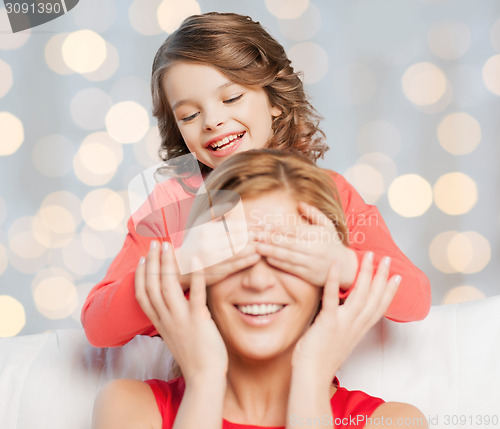 Image of happy mother and daughter playing guess who game