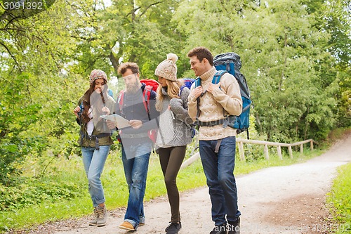 Image of group of smiling friends with backpacks hiking