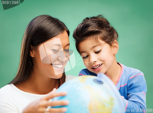 Image of happy teacher and little school girl with globe