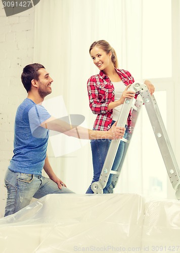 Image of smiling couple hanging curtains