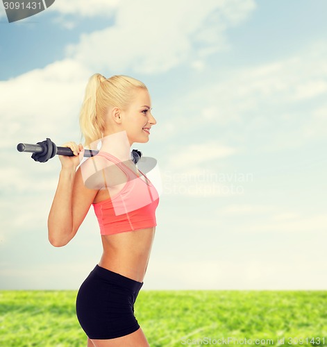 Image of smiling sporty woman exercising with barbell