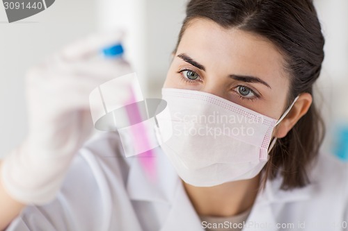 Image of close up of scientist with tube making test in lab