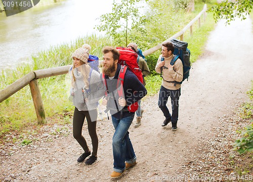 Image of group of smiling friends with backpacks hiking