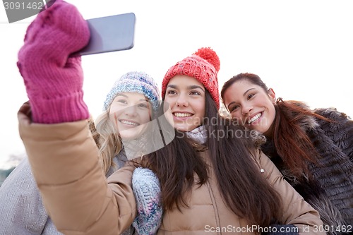 Image of happy teenage girls taking selfie with smartphone