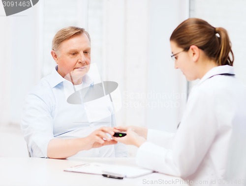 Image of female doctor or nurse measuring blood sugar value