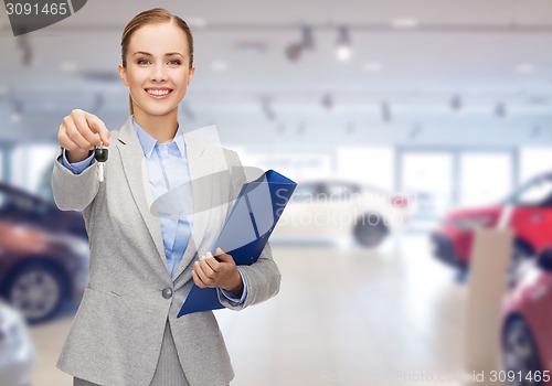 Image of businesswoman or saleswoman giving car key